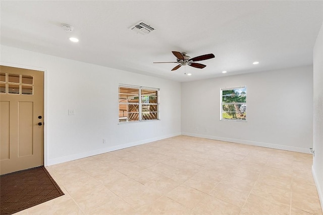 tiled empty room featuring ceiling fan