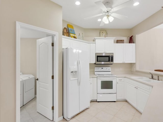 kitchen featuring light tile patterned flooring, white appliances, washer and clothes dryer, light countertops, and a sink