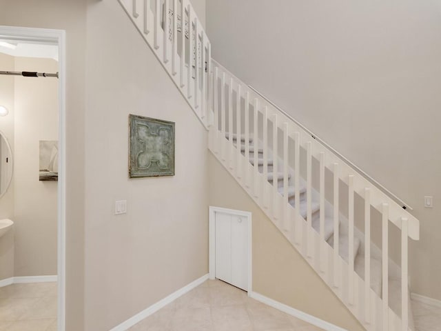 staircase with baseboards and tile patterned flooring