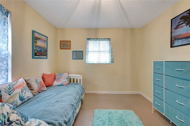 bedroom featuring a textured ceiling and light carpet