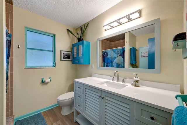 bathroom featuring toilet, vanity, a textured ceiling, and wood-type flooring