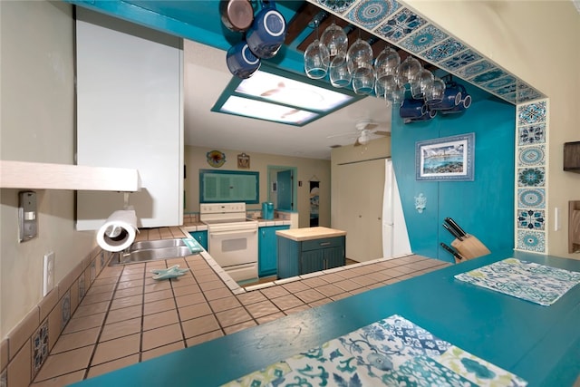 interior space featuring sink, tile patterned floors, and ceiling fan