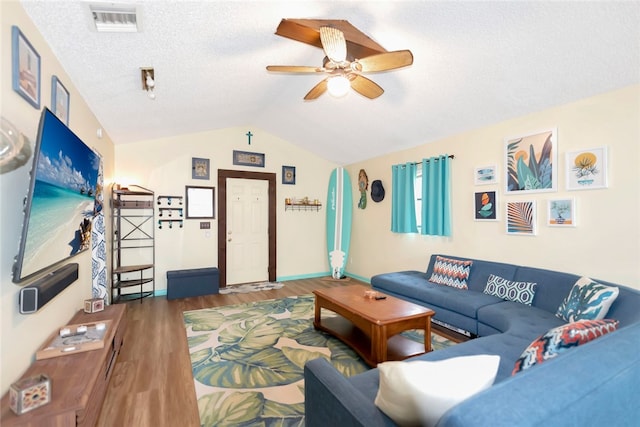 living room with dark wood-type flooring, ceiling fan, a textured ceiling, and vaulted ceiling