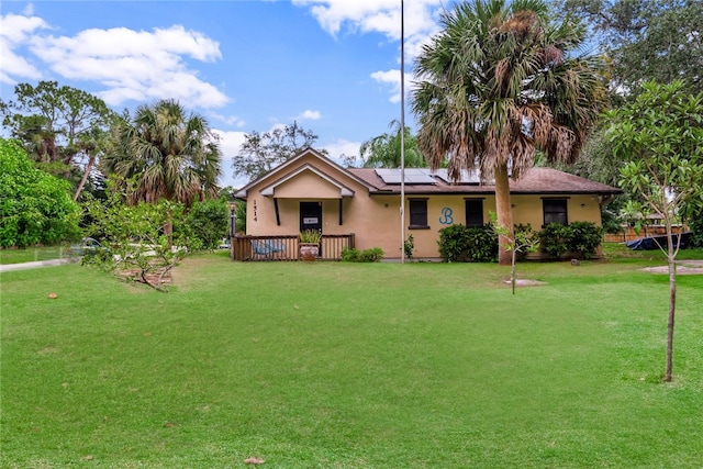 ranch-style house featuring a front lawn and solar panels