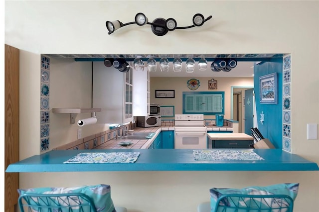 1514 Crowberry Ln, Sebastian, FL 32958 - kitchen featuring white range with electric stovetop, stainless steel microwave, a peninsula, and a kitchen bar