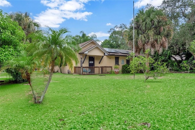 1514 Crowberry Ln, Sebastian, FL 32958 - view of front of house with roof mounted solar panels, a front yard, stucco siding, and covered porch