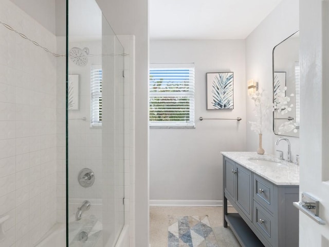 bathroom featuring washtub / shower combination, baseboards, and vanity