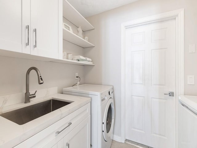 washroom with cabinets, sink, and washing machine and dryer