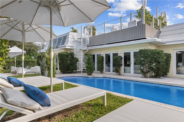 pool with french doors, a patio, and stairway