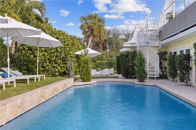 outdoor pool with a patio area and stairs