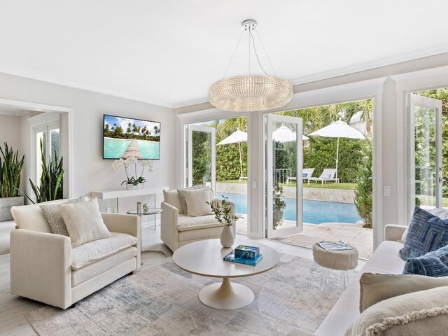 living room with crown molding and a notable chandelier