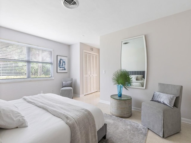 carpeted bedroom with a closet, visible vents, and baseboards