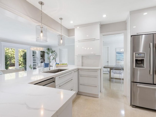 kitchen with a sink, pendant lighting, stainless steel appliances, white cabinetry, and modern cabinets