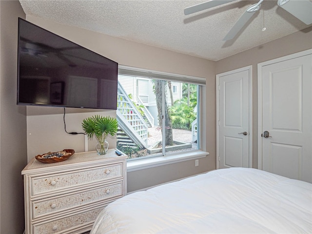 bedroom with a textured ceiling and ceiling fan