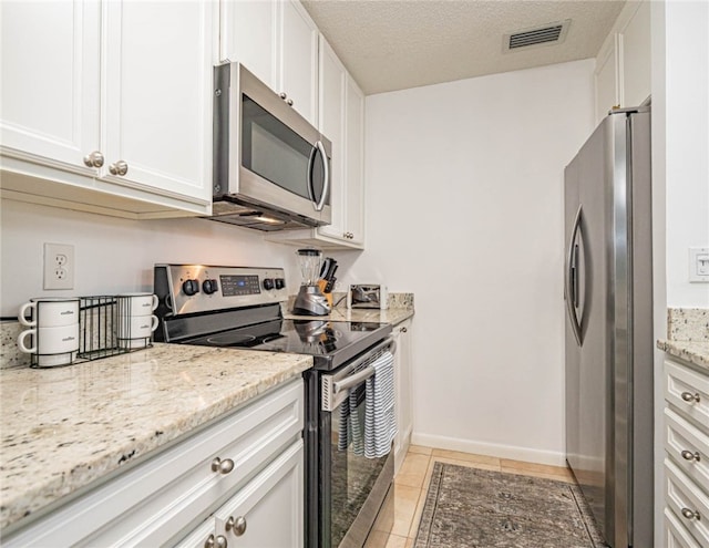 kitchen featuring white cabinets, appliances with stainless steel finishes, and light stone countertops