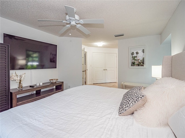 bedroom featuring a textured ceiling, ceiling fan, and a closet