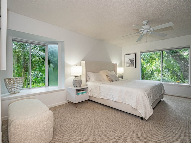 bedroom with ceiling fan, multiple windows, and carpet floors