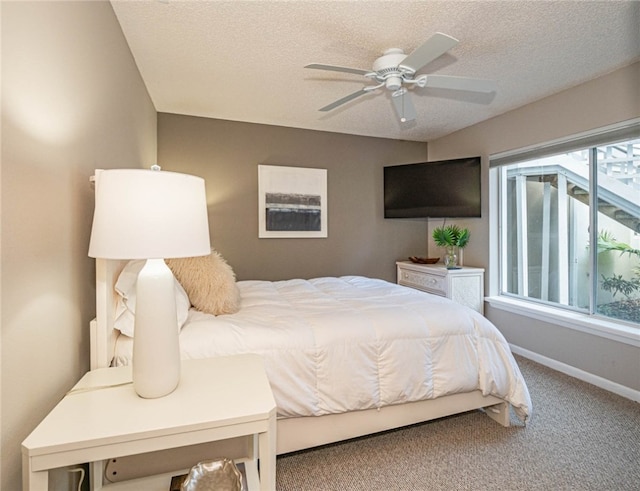 carpeted bedroom with ceiling fan and a textured ceiling