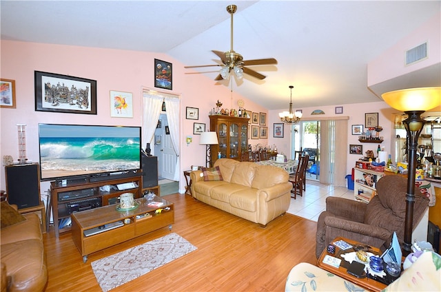 living room featuring ceiling fan with notable chandelier, light hardwood / wood-style flooring, and vaulted ceiling