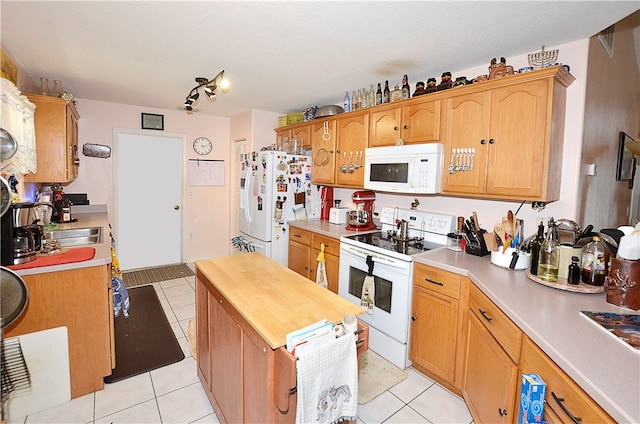 kitchen featuring white appliances, butcher block counters, and light tile patterned flooring