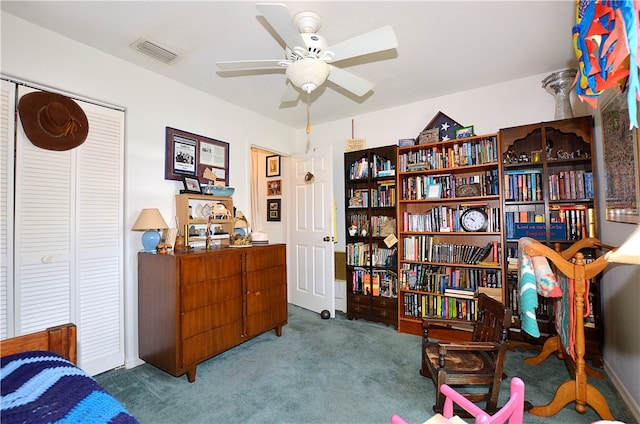 living area with ceiling fan and carpet