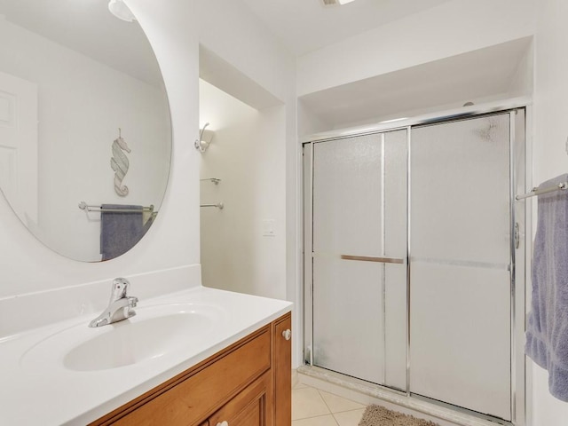 bathroom with vanity, a shower with shower door, and tile patterned flooring