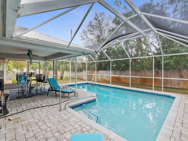 view of pool with a lanai, ceiling fan, and a patio area