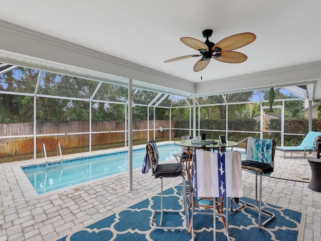 view of pool with ceiling fan, glass enclosure, and a patio area