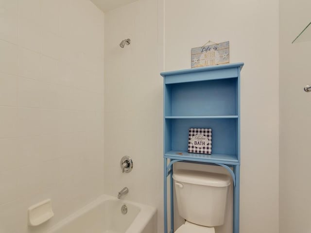 bathroom featuring tiled shower / bath and toilet