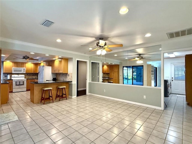 675 Colonial Dr, Vero Beach, FL 32962 - kitchen featuring white appliances, light tile patterned floors, crown molding, a ceiling fan, and dark countertops