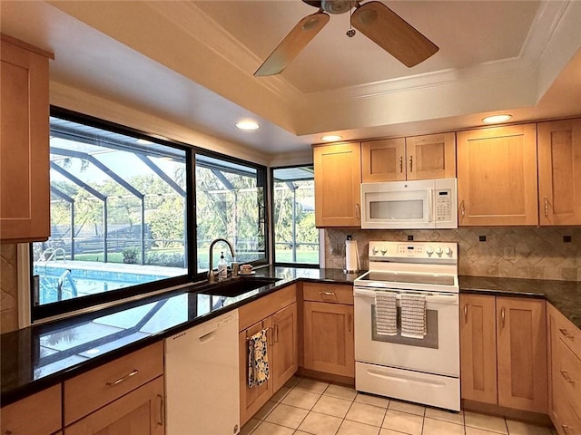 675 Colonial Dr, Vero Beach, FL 32962 - kitchen with white appliances, a ceiling fan, a tray ceiling, crown molding, and dark countertops
