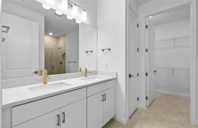 1223 Harper Way Unit 009, Vero Beach, FL 32960 - bathroom featuring a stall shower, double vanity, a spacious closet, tile patterned floors, and baseboards