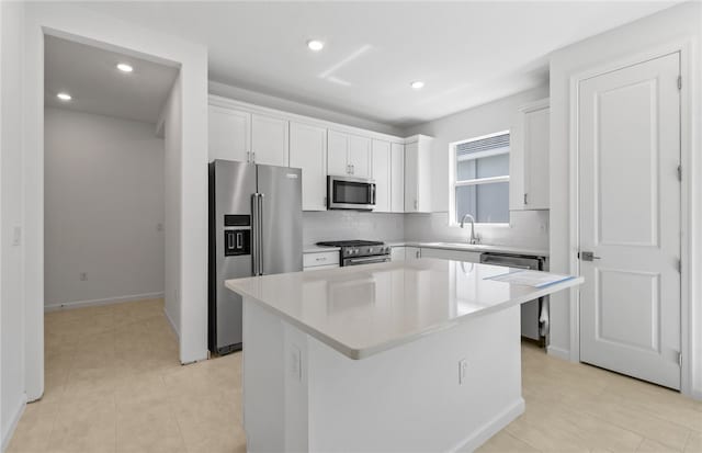 1223 Harper Way Unit 009, Vero Beach, FL 32960 - kitchen featuring stainless steel appliances, a kitchen island, recessed lighting, decorative backsplash, and white cabinets