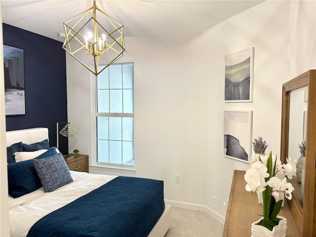 bedroom featuring a chandelier, tile patterned floors, and baseboards