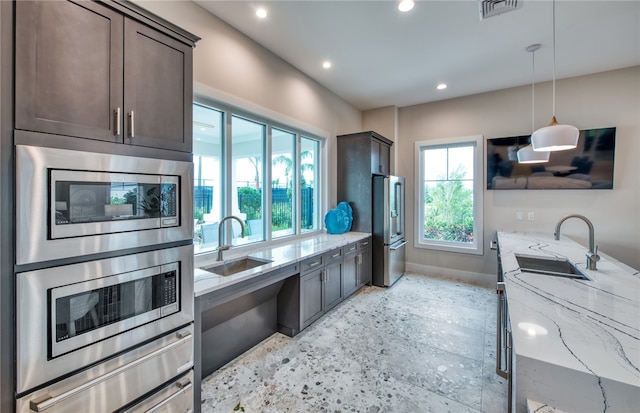 kitchen with a sink, appliances with stainless steel finishes, dark brown cabinetry, and recessed lighting