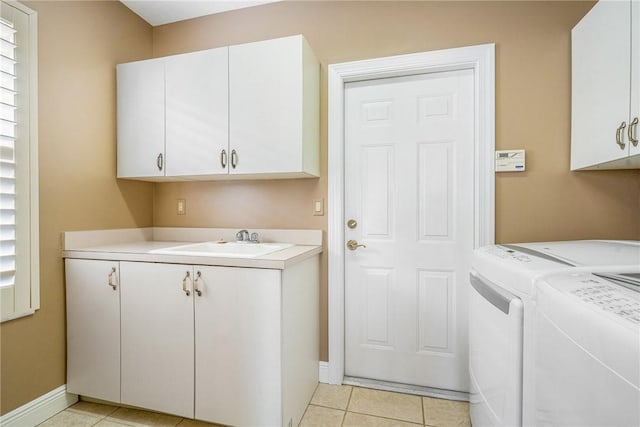 laundry room with cabinet space, independent washer and dryer, baseboards, and a sink