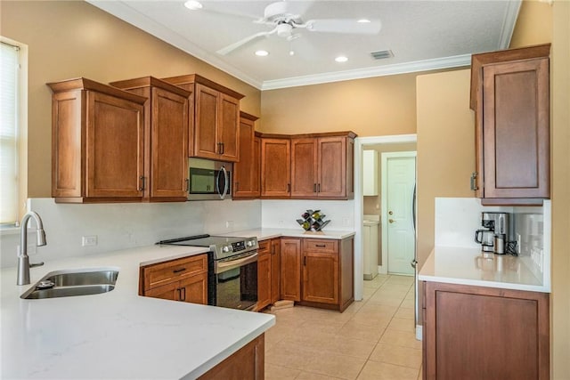 kitchen featuring visible vents, a sink, ornamental molding, a ceiling fan, and stainless steel appliances