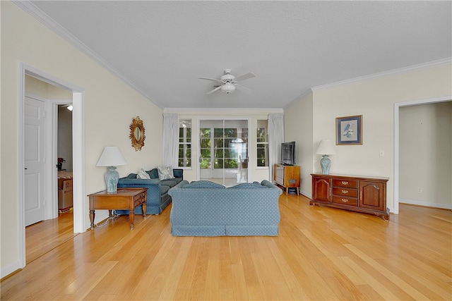 living room with ornamental molding, light wood-type flooring, and ceiling fan