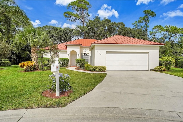2540 46th Rd, Vero Beach, FL 32966 - mediterranean / spanish-style home with a standing seam roof, driveway, a front lawn, and a garage