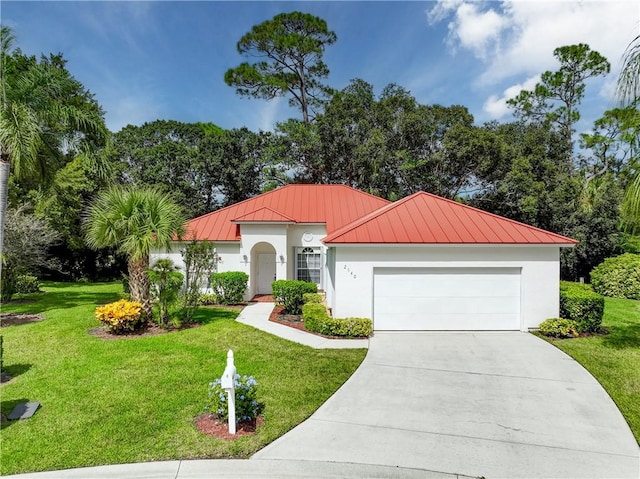 2540 46th Rd, Vero Beach, FL 32966 - mediterranean / spanish-style house featuring a standing seam roof, metal roof, a front yard, concrete driveway, and an attached garage