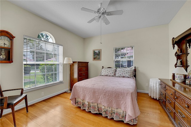 bedroom with multiple windows, ceiling fan, and light hardwood / wood-style flooring