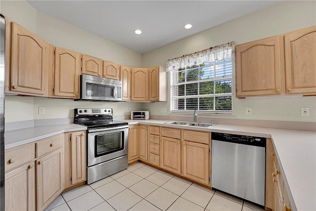 2540 46th Rd, Vero Beach, FL 32966 - kitchen with stainless steel appliances, a sink, light brown cabinets, light countertops, and light tile patterned flooring