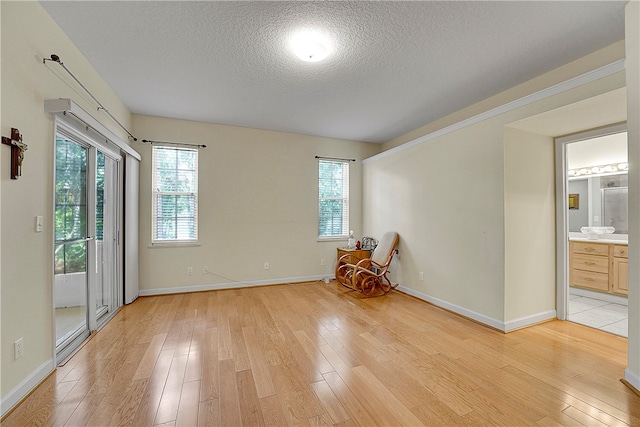 spare room featuring a textured ceiling and light wood-type flooring