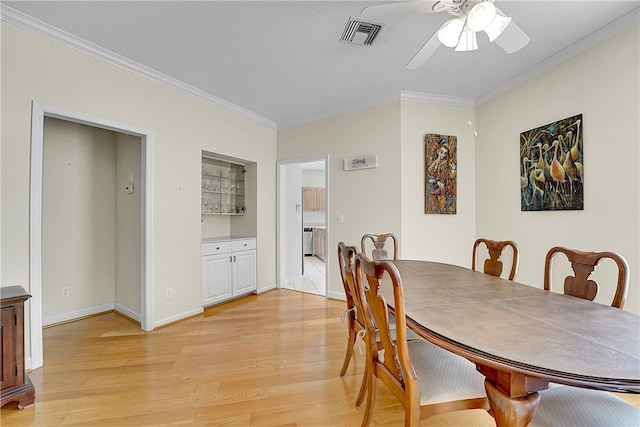 dining room with a textured ceiling, light hardwood / wood-style flooring, ceiling fan, and crown molding