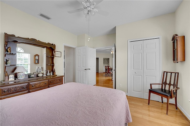 bedroom featuring ceiling fan, a closet, and light wood-type flooring