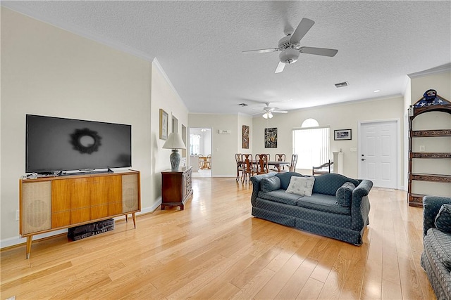 2540 46th Rd, Vero Beach, FL 32966 - living room featuring a ceiling fan, crown molding, light wood finished floors, a textured ceiling, and baseboards