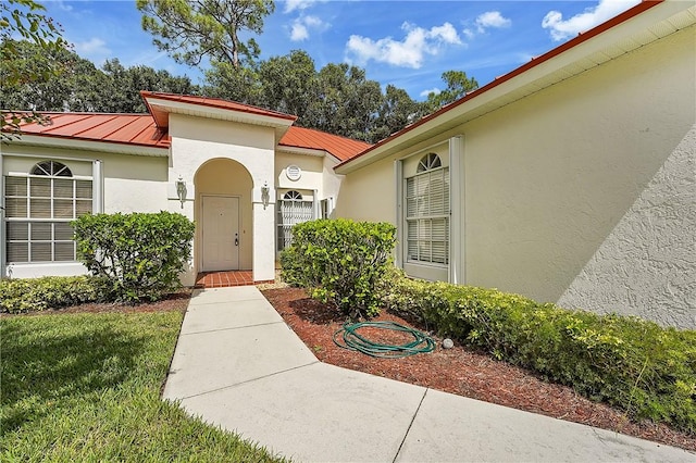 2540 46th Rd, Vero Beach, FL 32966 - property entrance with stucco siding, a standing seam roof, and metal roof