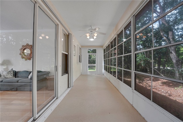 unfurnished sunroom with ceiling fan