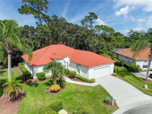 2540 46th Rd, Vero Beach, FL 32966 - view of front of home with driveway, a front lawn, metal roof, and a garage