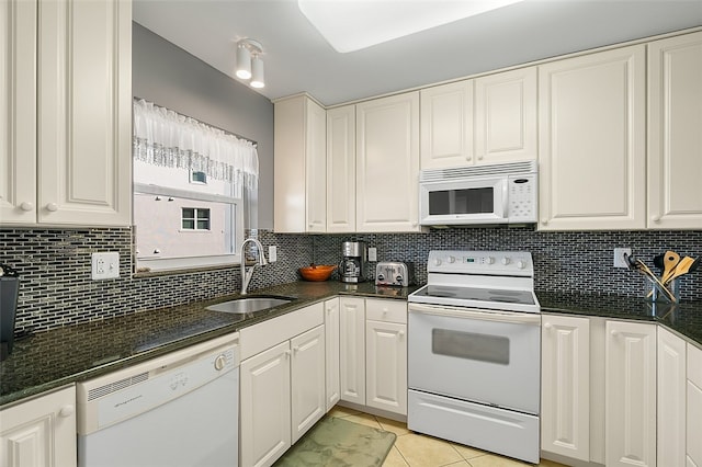 kitchen featuring decorative backsplash, white appliances, sink, light tile patterned floors, and white cabinetry